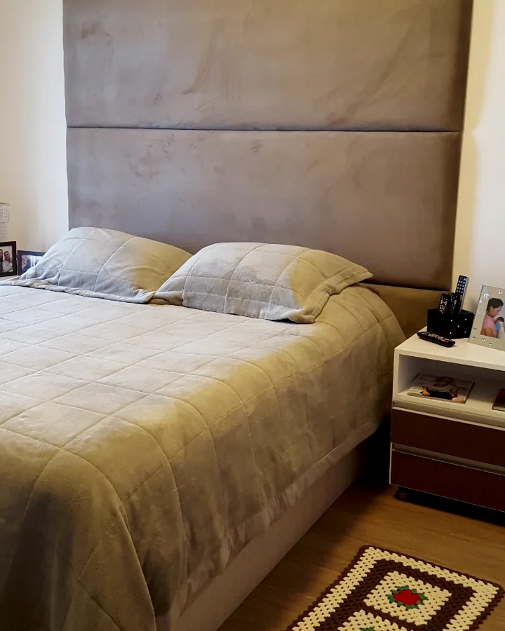 Cama com cabeceira estofada alongada até o teto em painéis horizontais na cor bege fendi.